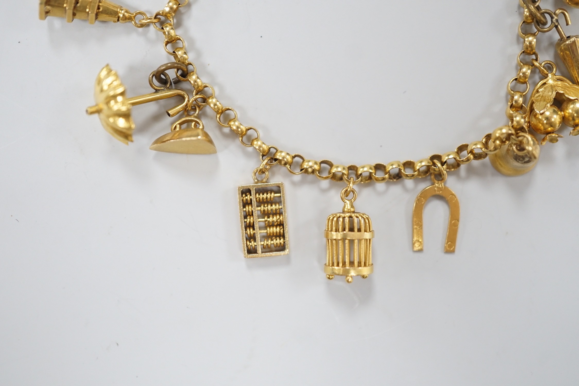 A Chinese yellow metal charm bracelet, hung with thirteen assorted yellow metal charms including four 9ct, 15.5cm